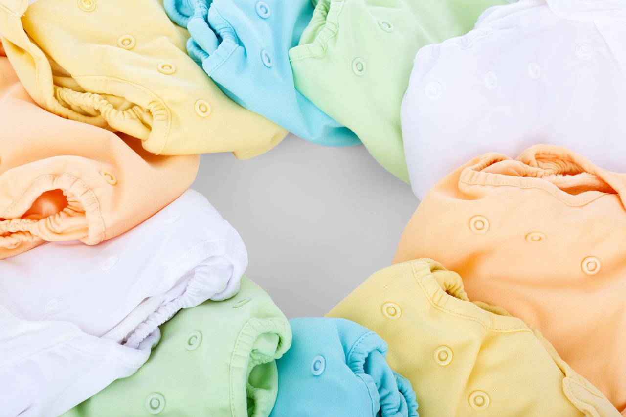 our-story-02 A top-view of colorful cloth diapers arranged in a circular pattern showcasing vivid hues and comfort.